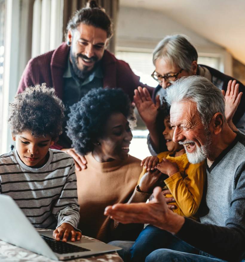 Portrait of a happy multigeneration family using electronic devices at home together